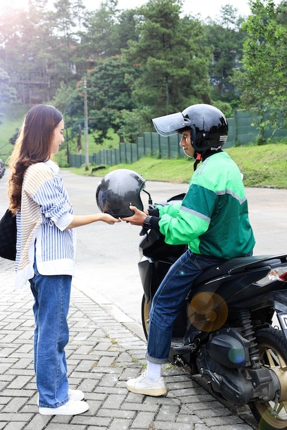 Chauffeur geeft helm aan passagier