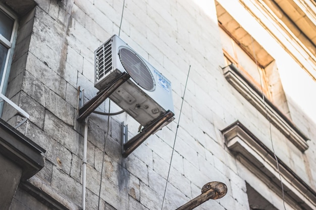 Cheap air conditioner on the wall of the house Appearance problems of city streets Urbanism concept