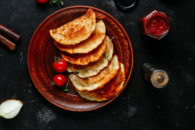 Chebureks with meat on a plate. Fried pies