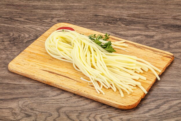 Chechil spaghetti cheese over board