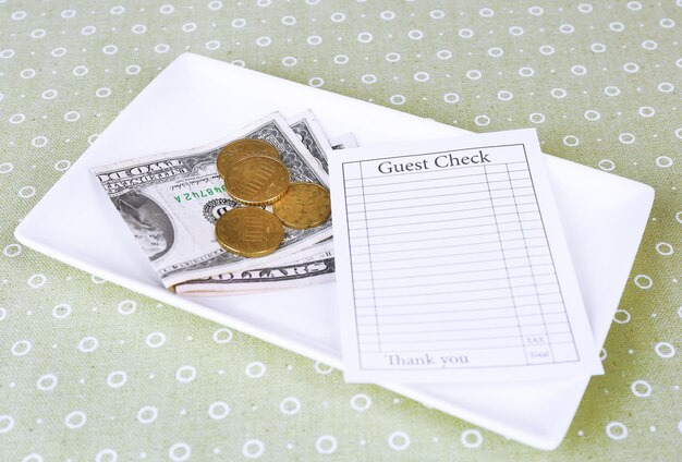 Photo check and money on tray on table closeup