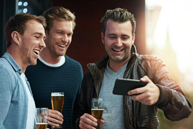 Посмотрите это видео Снимок группы друзей, которые вместе пьют пиво, стоя вместе на балконе.