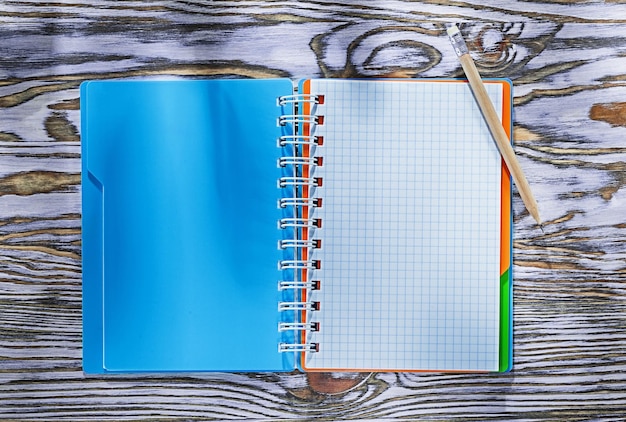 Checked spiral copybook pencil on wooden board