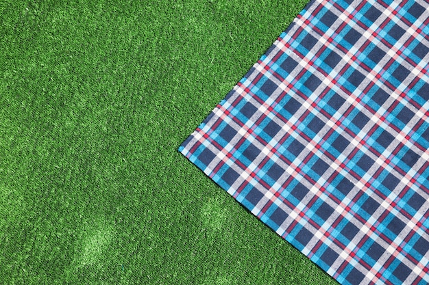 Photo checkered table cloth on green turf