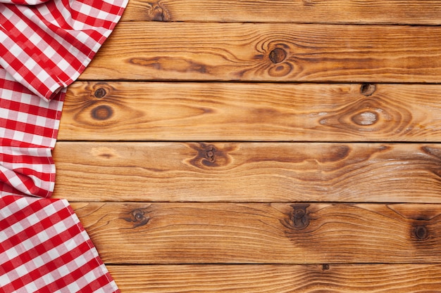 Checkered tablecloth on wooden table background