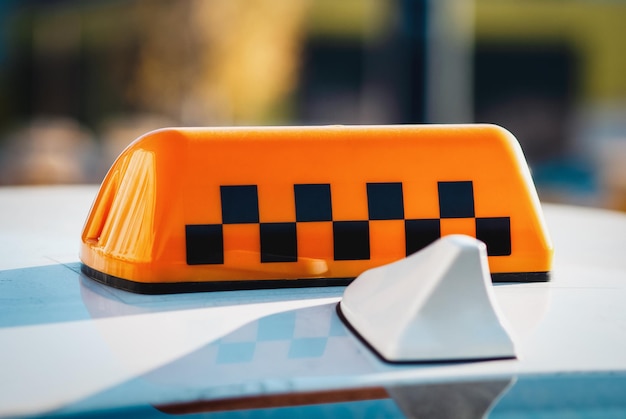 Checkered taxi sign on top of the car closeup