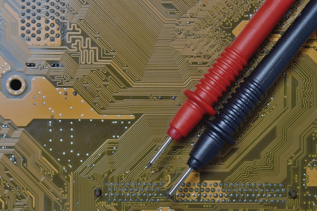 Photo checking the computer motherboard for problems using a multimeter.