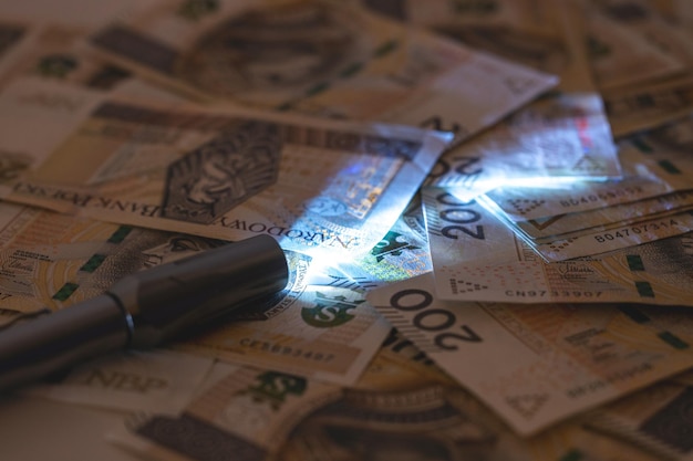 Checking counterfeit money with an ultraviolet lamp Polish zloty