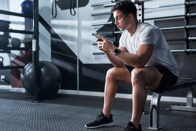 Photo checking out the latest fitness apps shot of a sporty young man using a cellphone in a gym