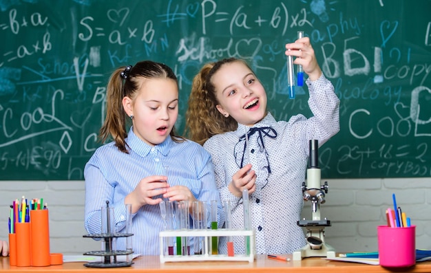 Checking the result little children at school lesson little\
kids learning chemistry in school lab students doing biology\
experiments with microscope chemistry back to school happy\
childrens day