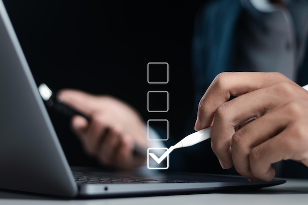 Checklist concept Businessman using laptop for checking mark on checkboxes