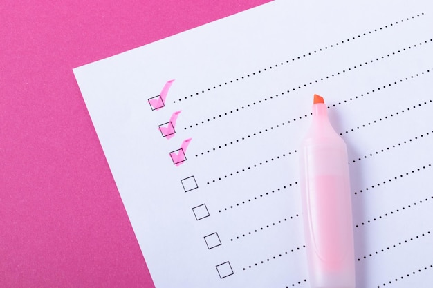 Checklist met roze gemarkeerde punten en marker op roze achtergrond