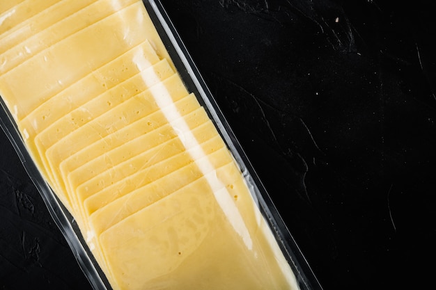 Cheddar cheese in vacuum pack, on black table