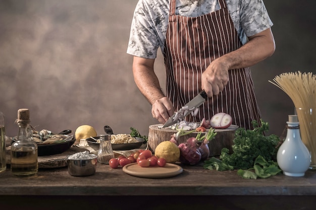 Photo cheef cook prepairing spaghetti on a kitchen.