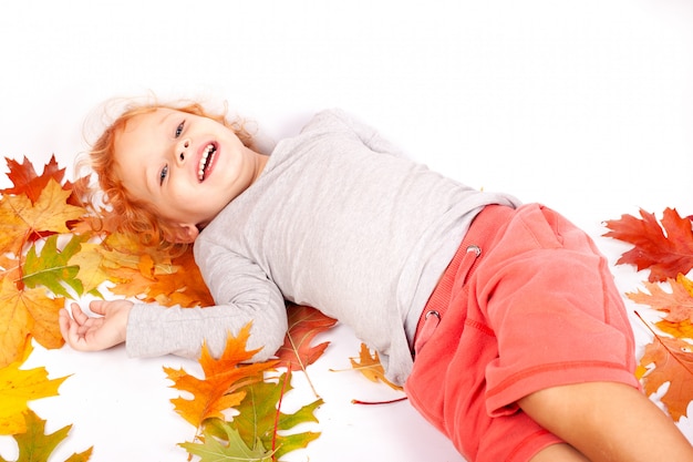 陽気な2〜3歳の赤毛のスタジオの床に横たわった少女