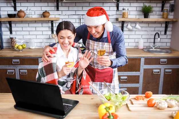 陽気な成人男性と新年やクリスマスを祝うキッチンの女性。