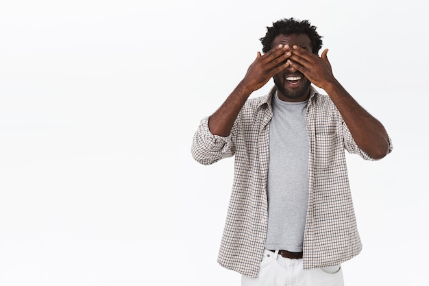 Cheerful african-american bearded father playing with kids peekaboo