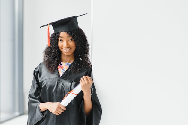 Cheerful african-american graduate student with diploma in her hand