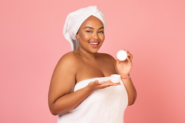 Cheerful African American Lady Holding Moisturizer Jar Over Pink Background