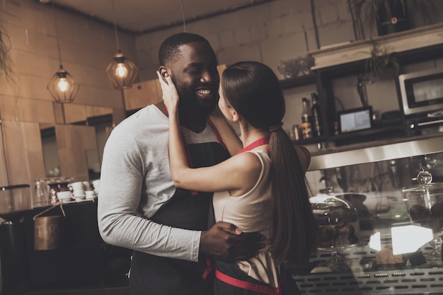 Cheerful African American man hugs beautiful girl