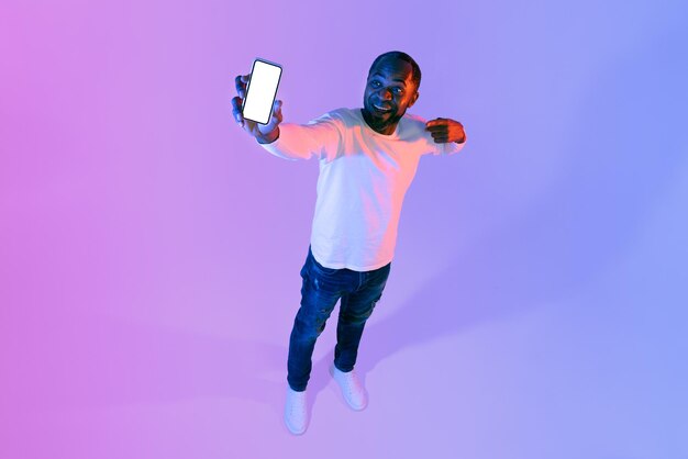 Cheerful african american mature man showing cell phone mockup