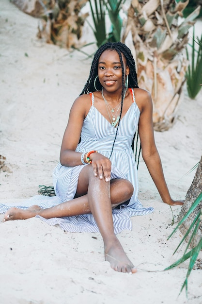 cheerful african american young woman having fun on the beach at sunset