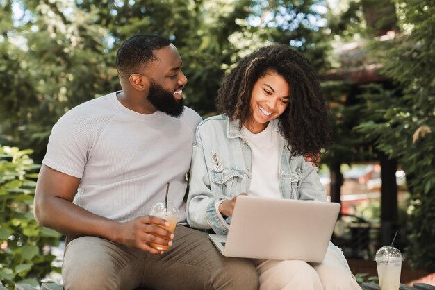 Cheerful africanamerican young romantic couple friends watching\
movie comedy online together