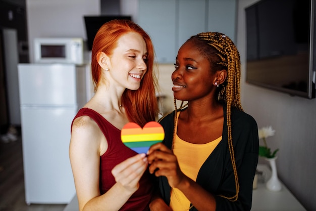 Cheerful afro and european lesbian women at home on the bed