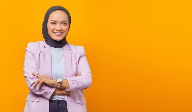 Cheerful asian business woman crossing her arms in business suit