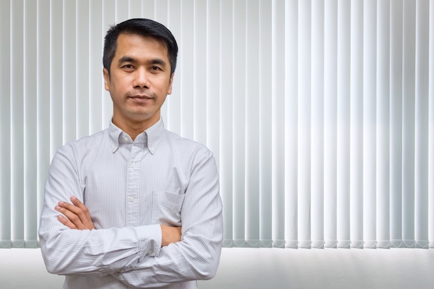 Cheerful asian businessman with crossed arms