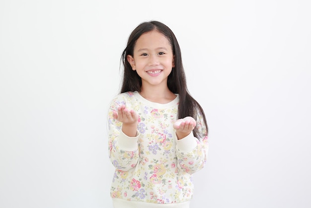 Cheerful asian little girl with lotion cream in hands on white background