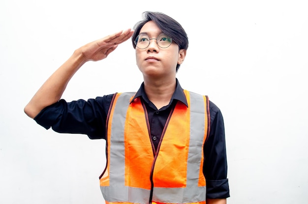 Cheerful asian male construction manager, engineer, builder in safety helmet and vest saluting