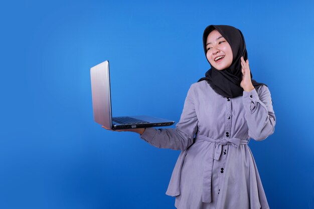 Cheerful Asian woman bring and looking her laptop