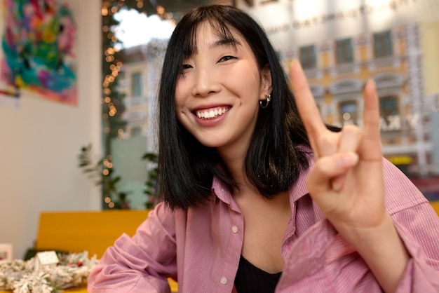 Cheerful asian woman showing thumbs up positive mood