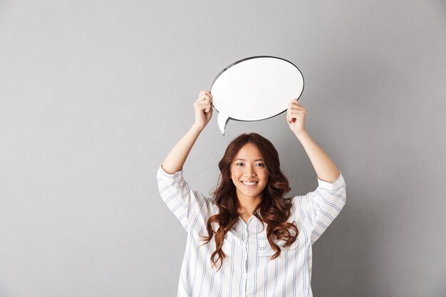 Cheerful asian woman standing isolated, showing empty speech bubble