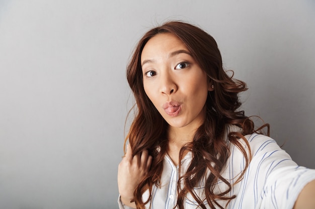 고립 된 서 쾌활 한 아시아 여자는 selfie를 복용