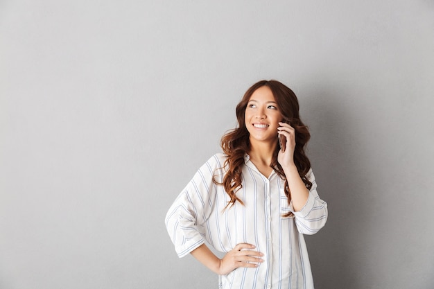 Cheerful asian woman standing isolated