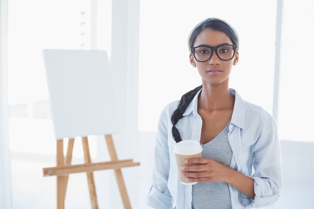 Cheerful attractive artist holding cup of coffee