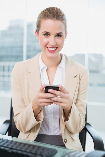 Photo cheerful attractive businesswoman text messaging