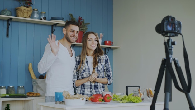Веселая привлекательная пара записывает видео-блог о еде о кулинарии