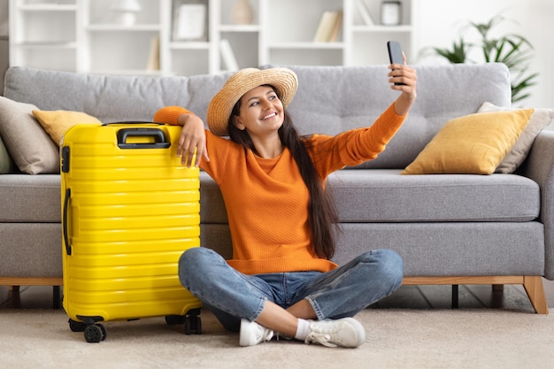 陽気な魅力的な若いインド人女性旅行者が自分撮りで休暇に行く