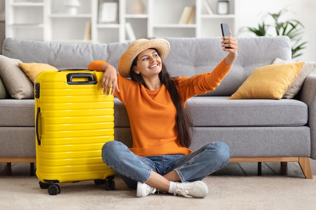 Cheerful attractive young indian woman traveler going vacation taking selfie