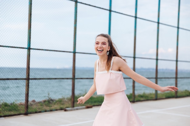 Cheerful attractive young woman laughing and having fun outdoors