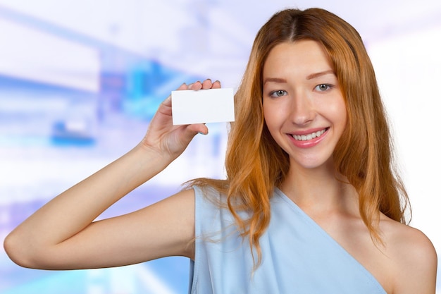 Foto giovane donna attraente allegra che mostra foglio di carta in bianco con lo spazio della copia