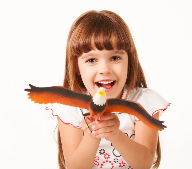 Cheerful baby girl playing win toy.