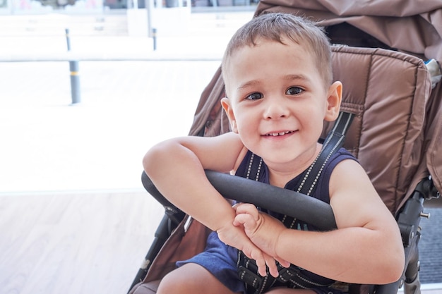 Cheerful baby sitting in a wheelchair and smiling