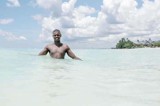 Photo cheerful bare-chested african american man looking at camera with smile