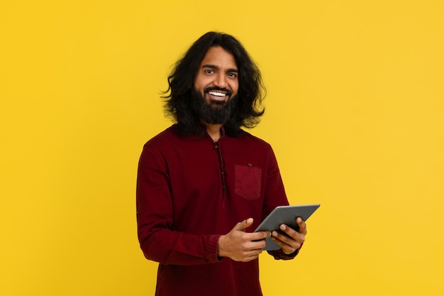 디지털 태블릿을 들고 있는 기쁜 수염이 있는 인도인 남자