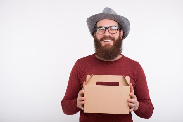 Cheerful bearded man is smiling at the camera holding a lunch box. It's time to eat.