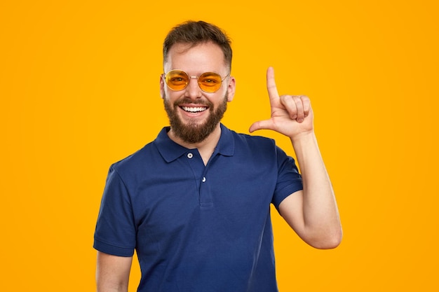 Cheerful bearded man pointing up